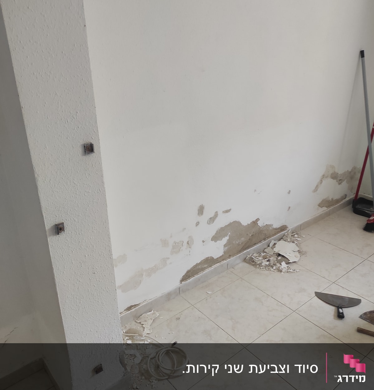 קיר מתקלף עם כלי עבודה על הרצפה